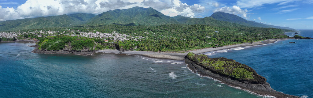Panorama de Domoni, deuxième ville d'Anjouan, entourée par les reliefs montagneux de l'île et bordée par les eaux de l'océan Indien